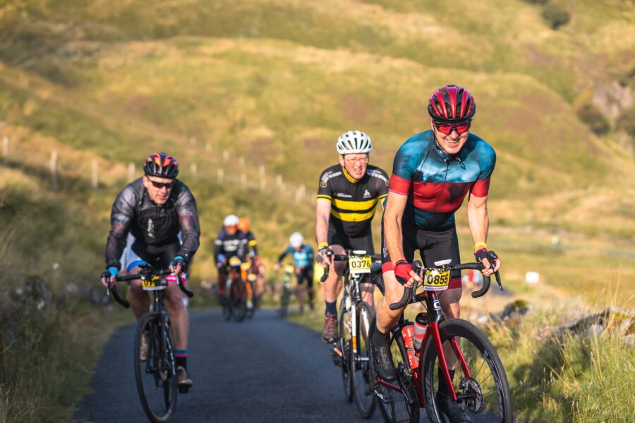 Three cyclists climbing hill